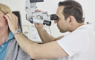 Arzt untersucht Patientin am Ohr